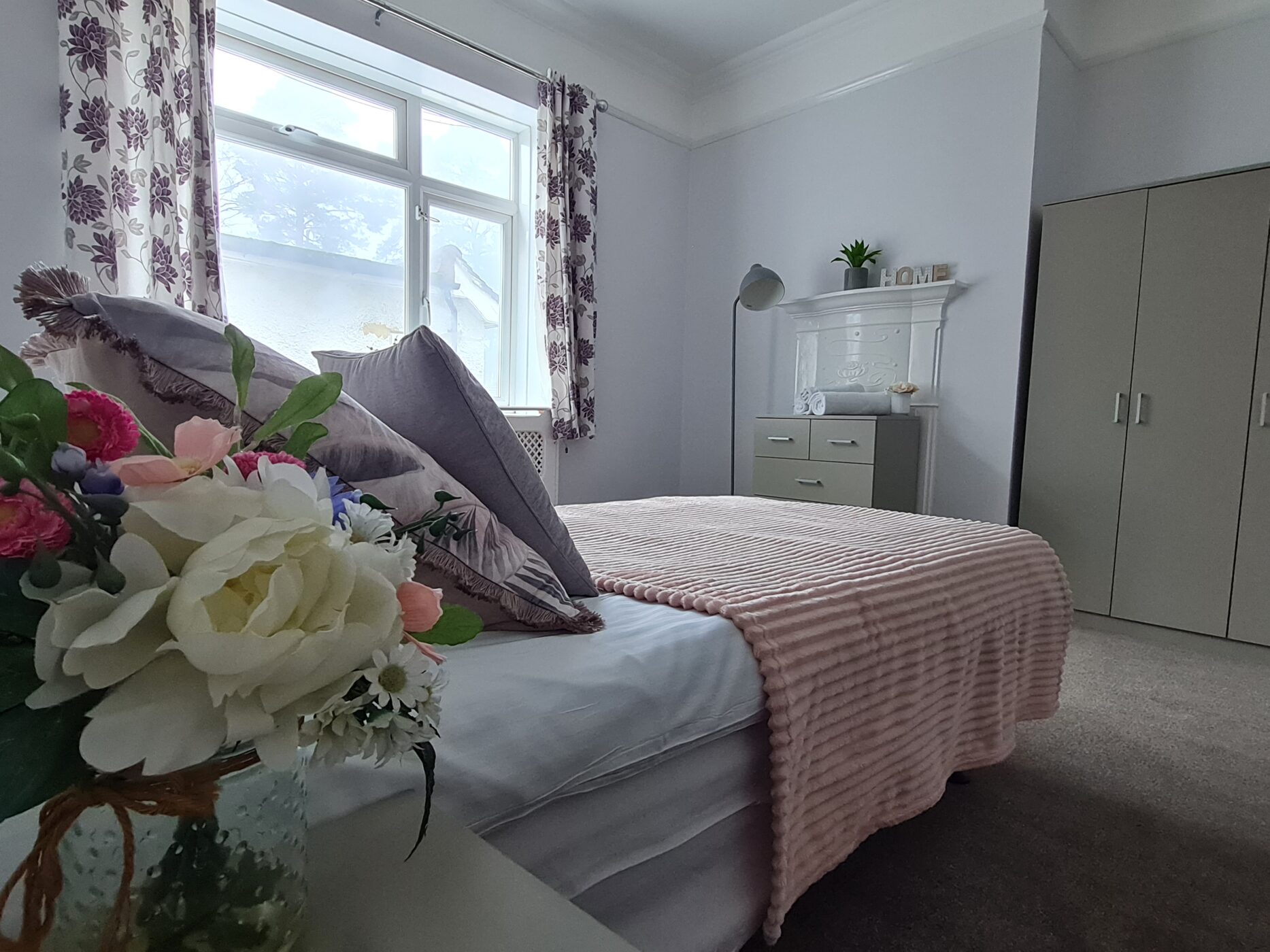 Bedroom with bed, furniture and flower arrangement