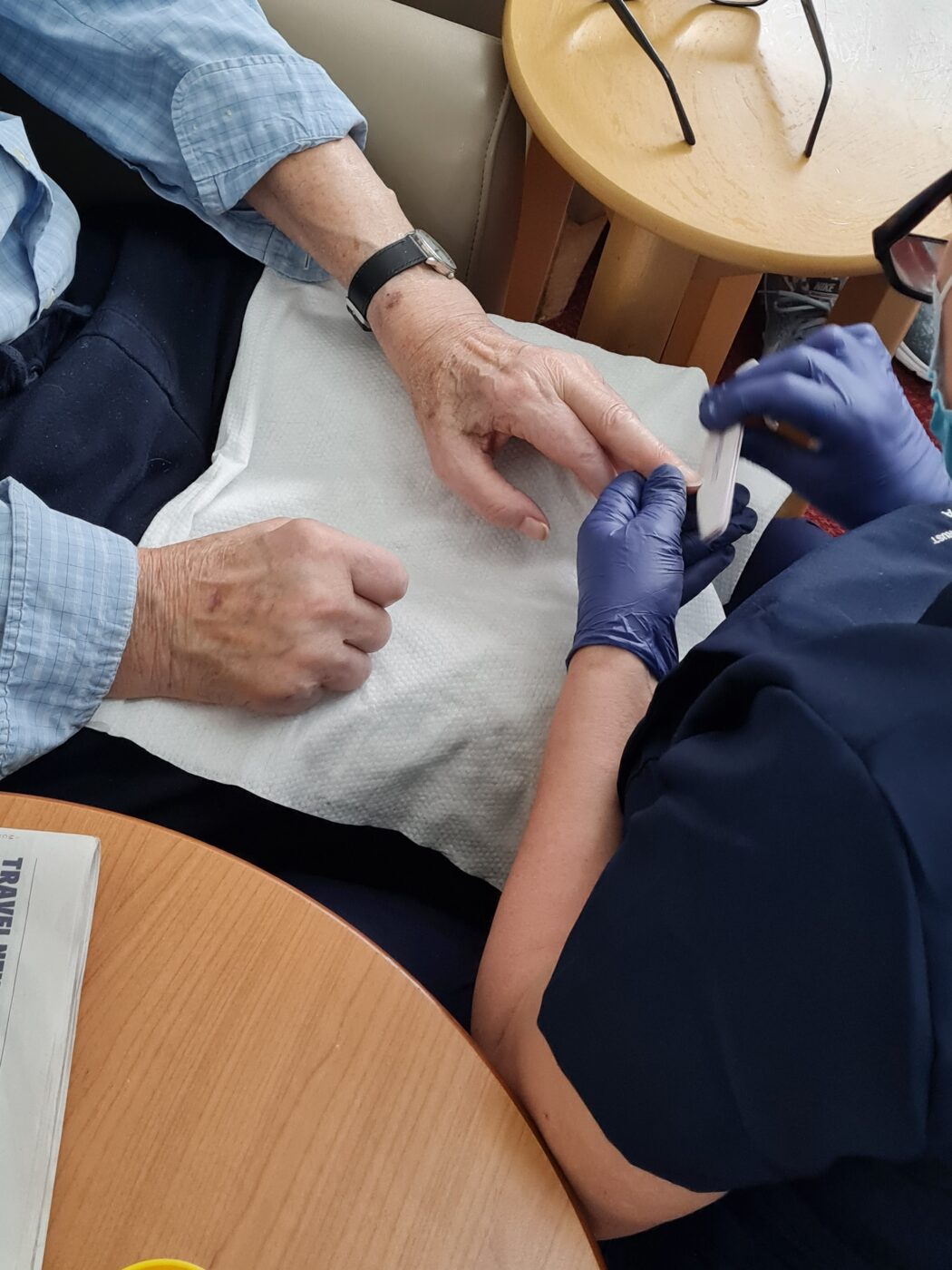 Older woman receiving a manicure from a member of staff