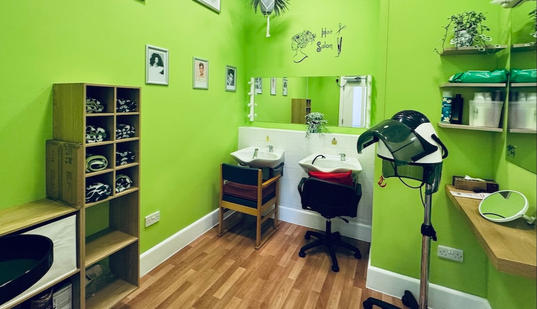 Green hair salon with mirror, sink and hairdryer