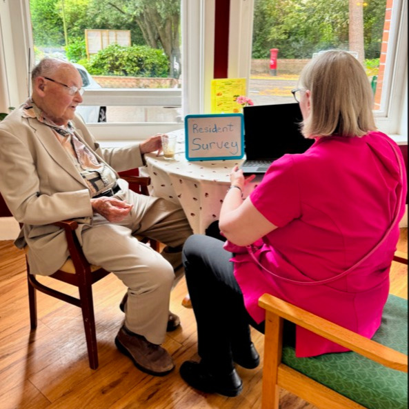 Resident and staff member sat having a conversation