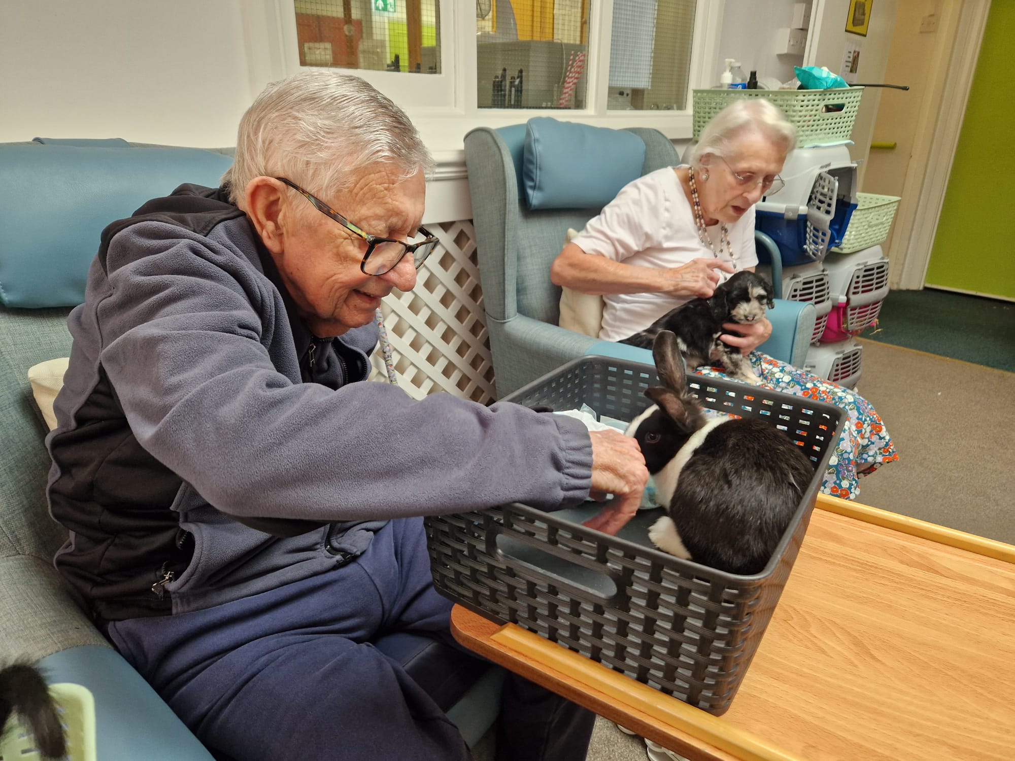 Two residents interacting with animals on their laps