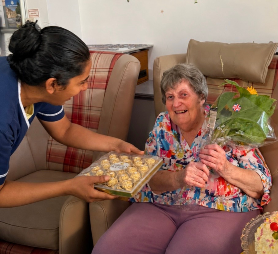 An older woman and staff member reading a book