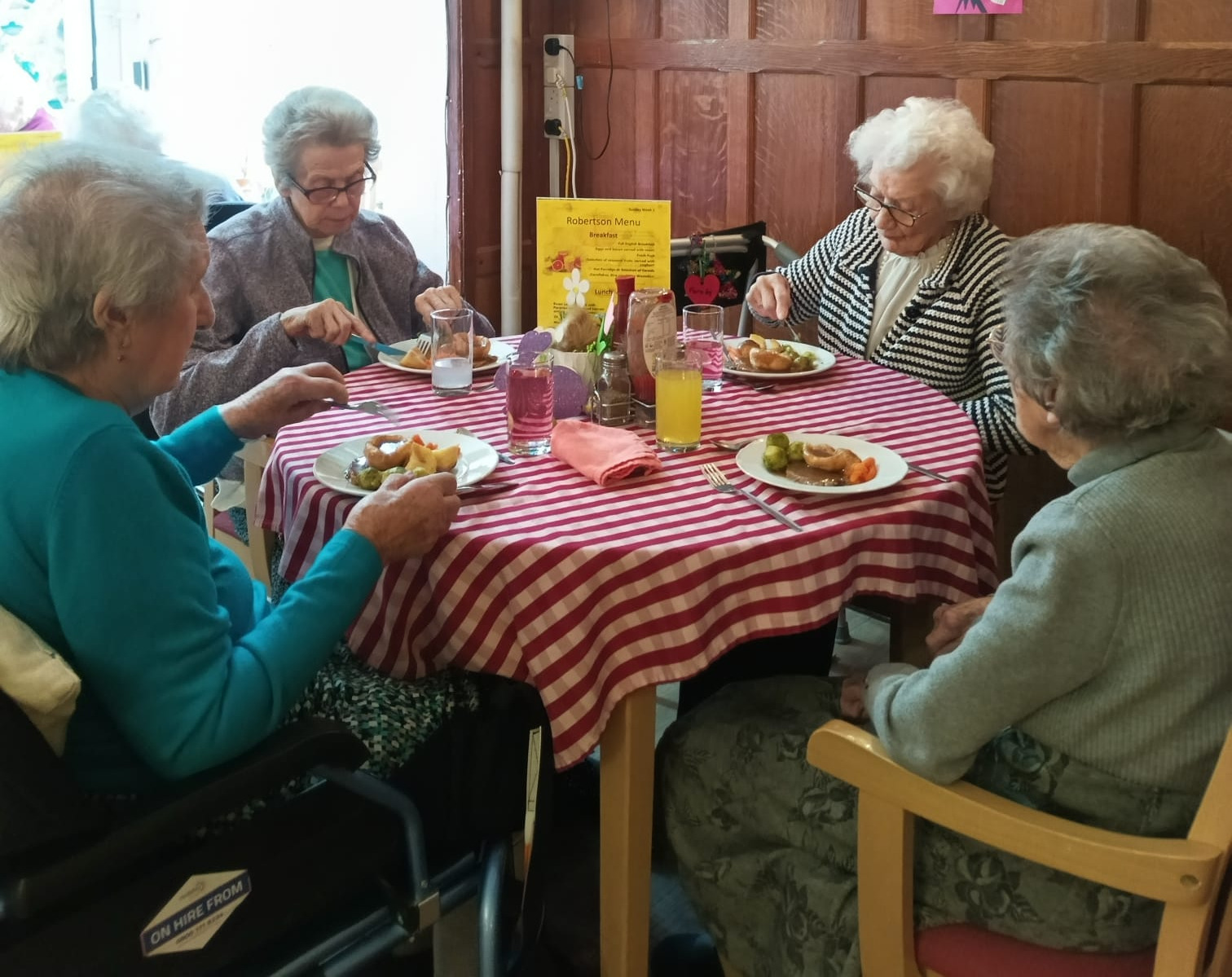 A group of people sat around a table eating a meal