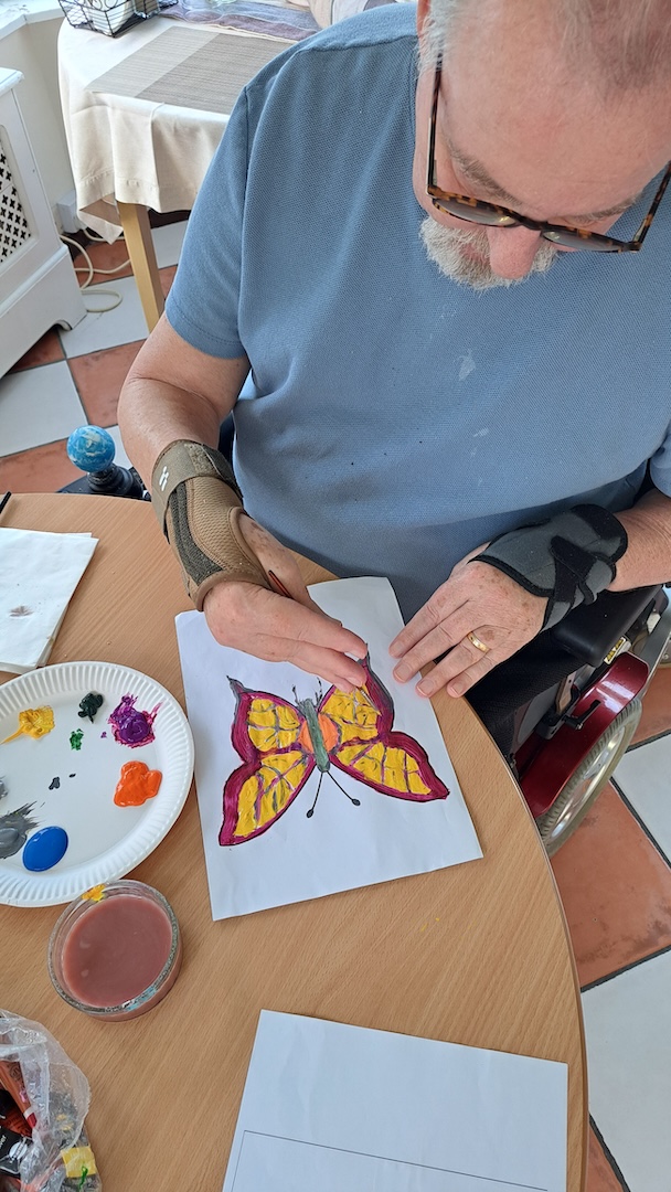 A man painting a picture of a butterfly