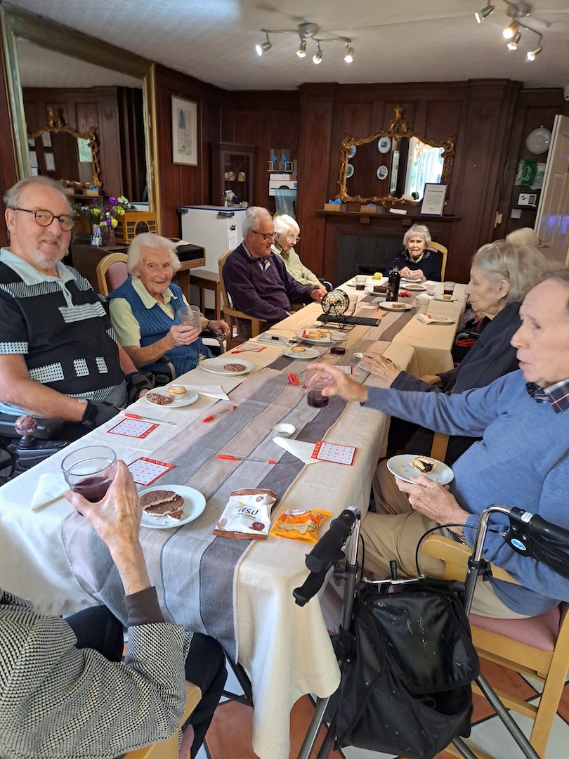 A group of people sat around a large table with drinks and games