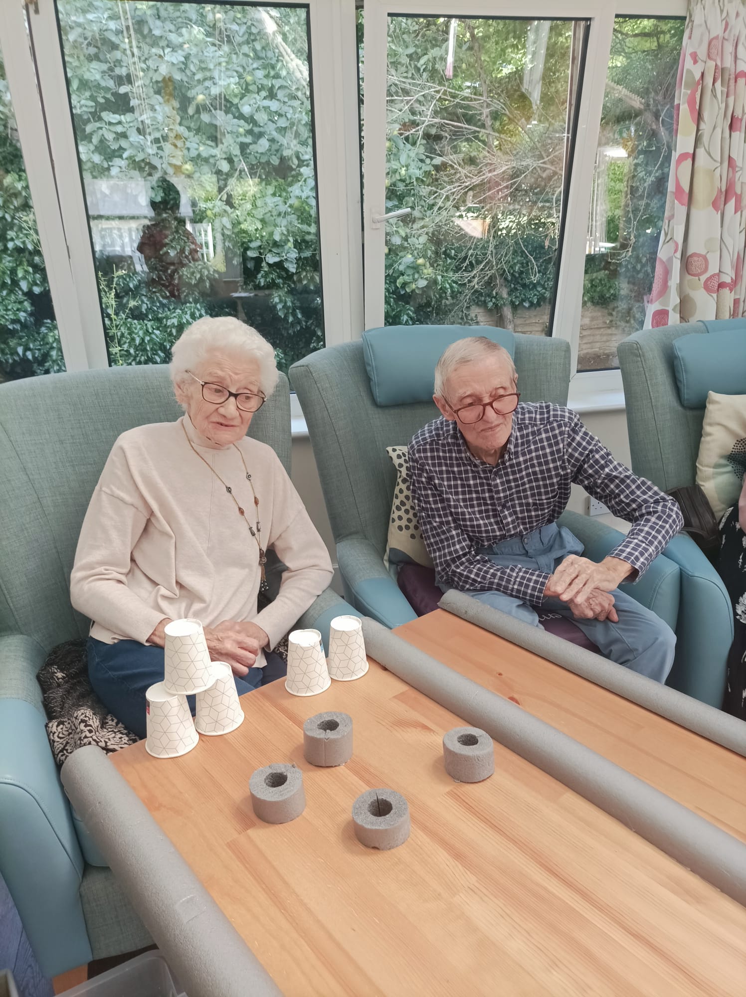 An older man and woman sat playing games