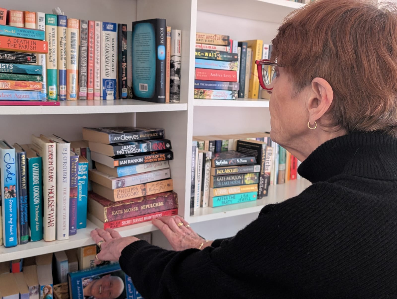 A lady looking at shelves of books