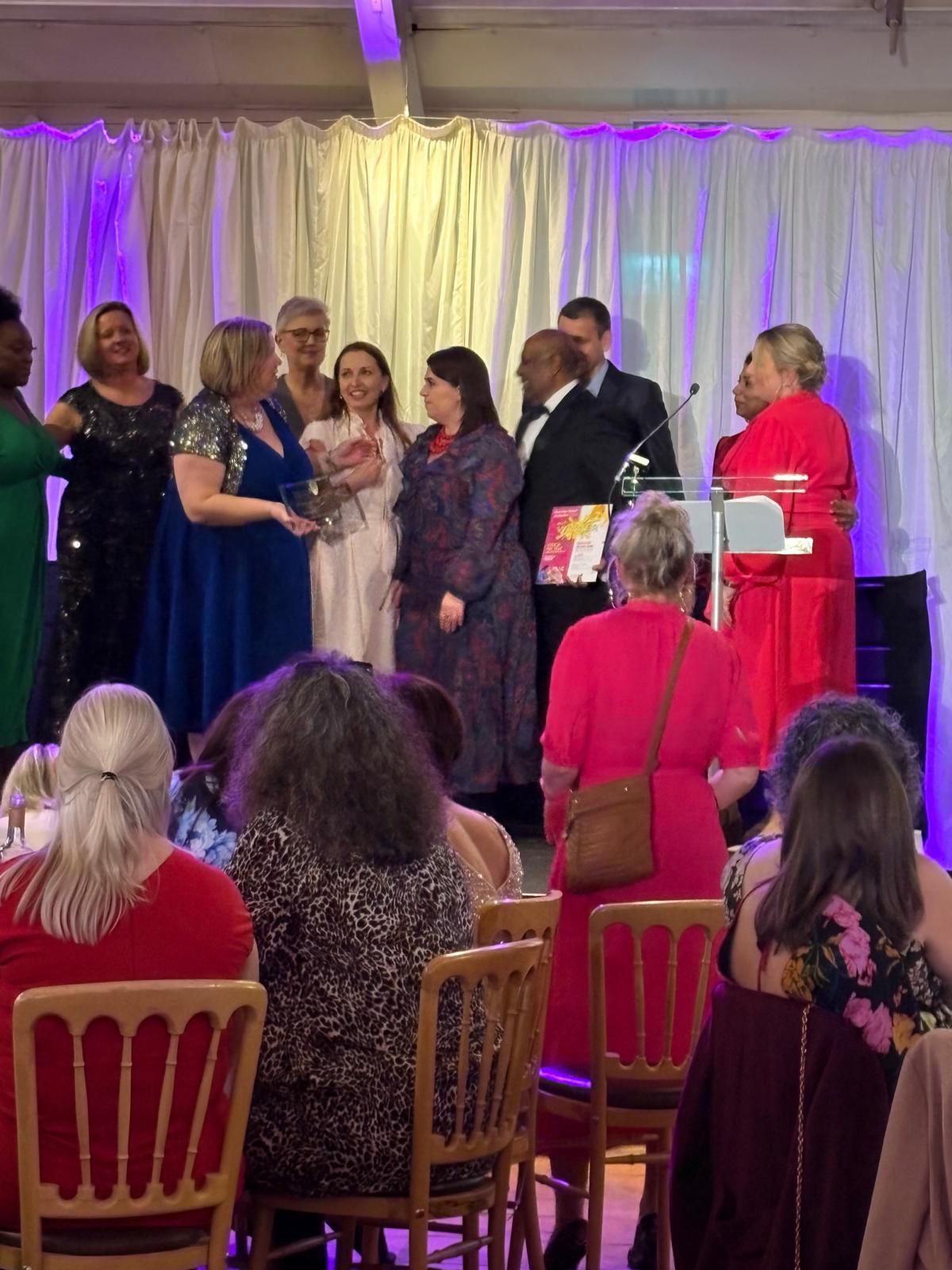 A group of people on stage accepting an award
