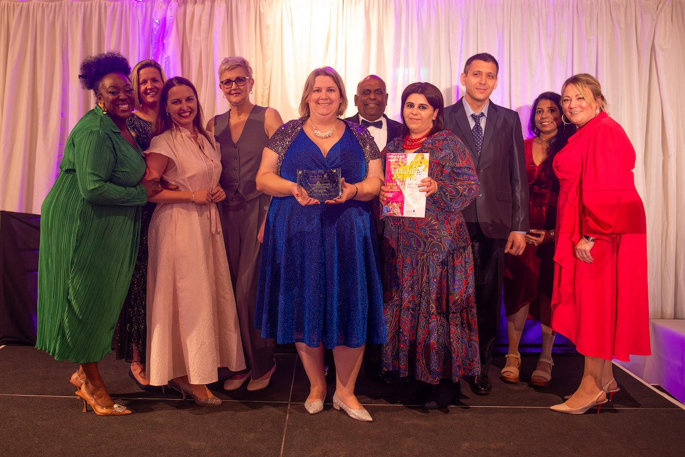 A group of smartly dressed people with an award