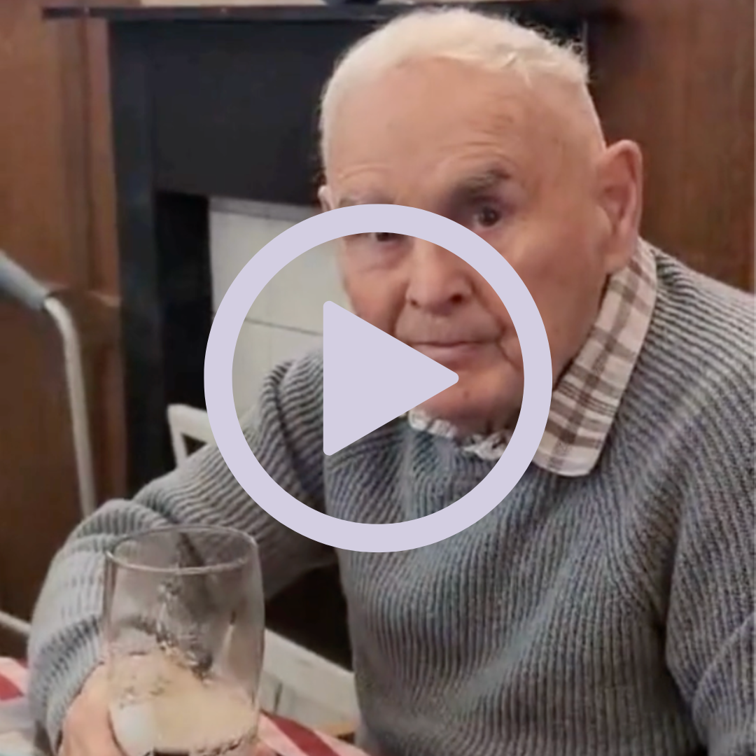 An older gentleman sitting with a pint of beer