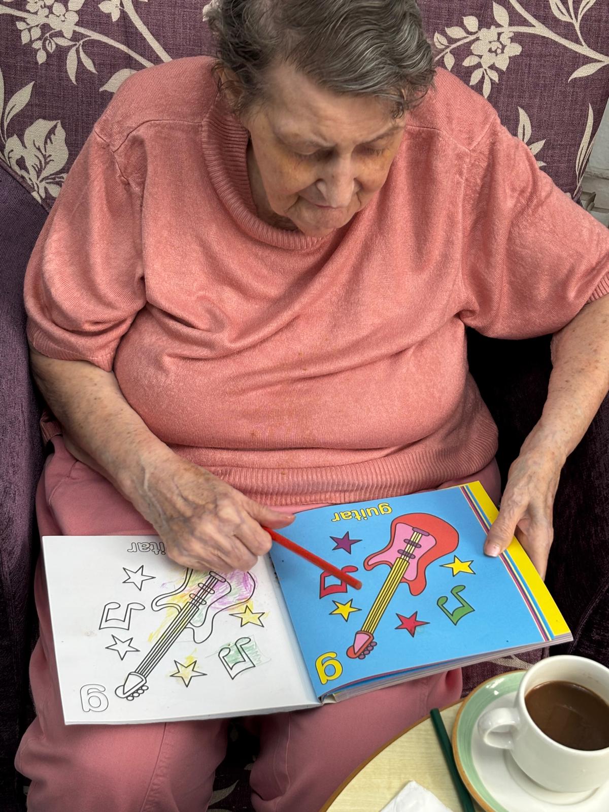 An elderly woman doing some colouring 