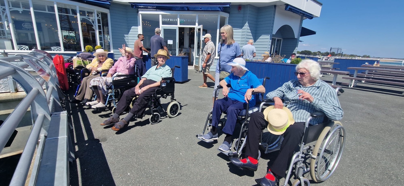 A group of elderly people on the seafront promenade