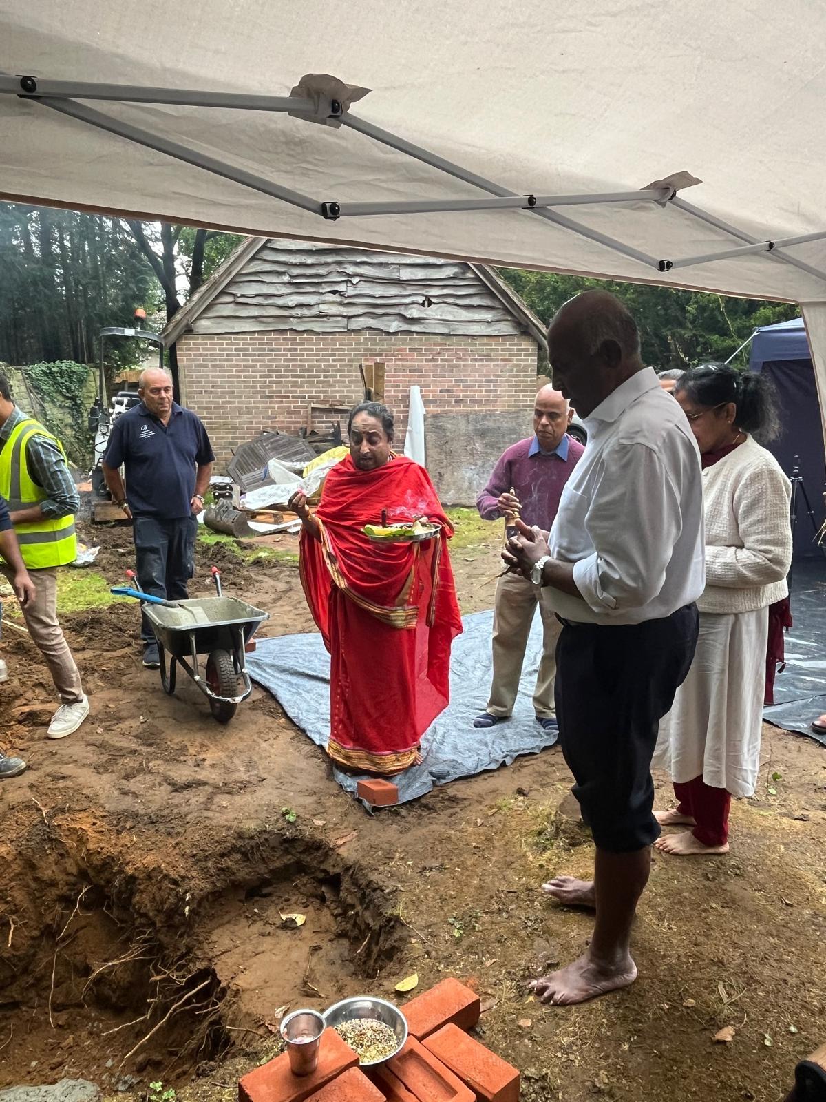 People taking part in a religious ceremony outdoor to bless a building project