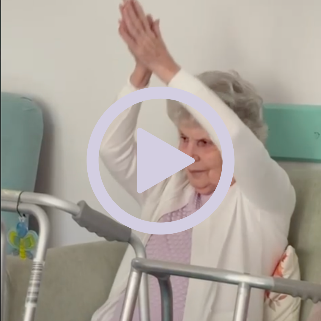 Elderly woman taking part in armchair based exercises