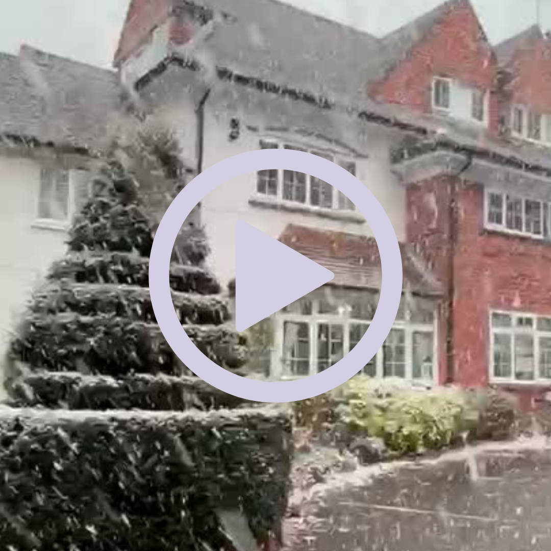 Snowfall outside of a building exterior