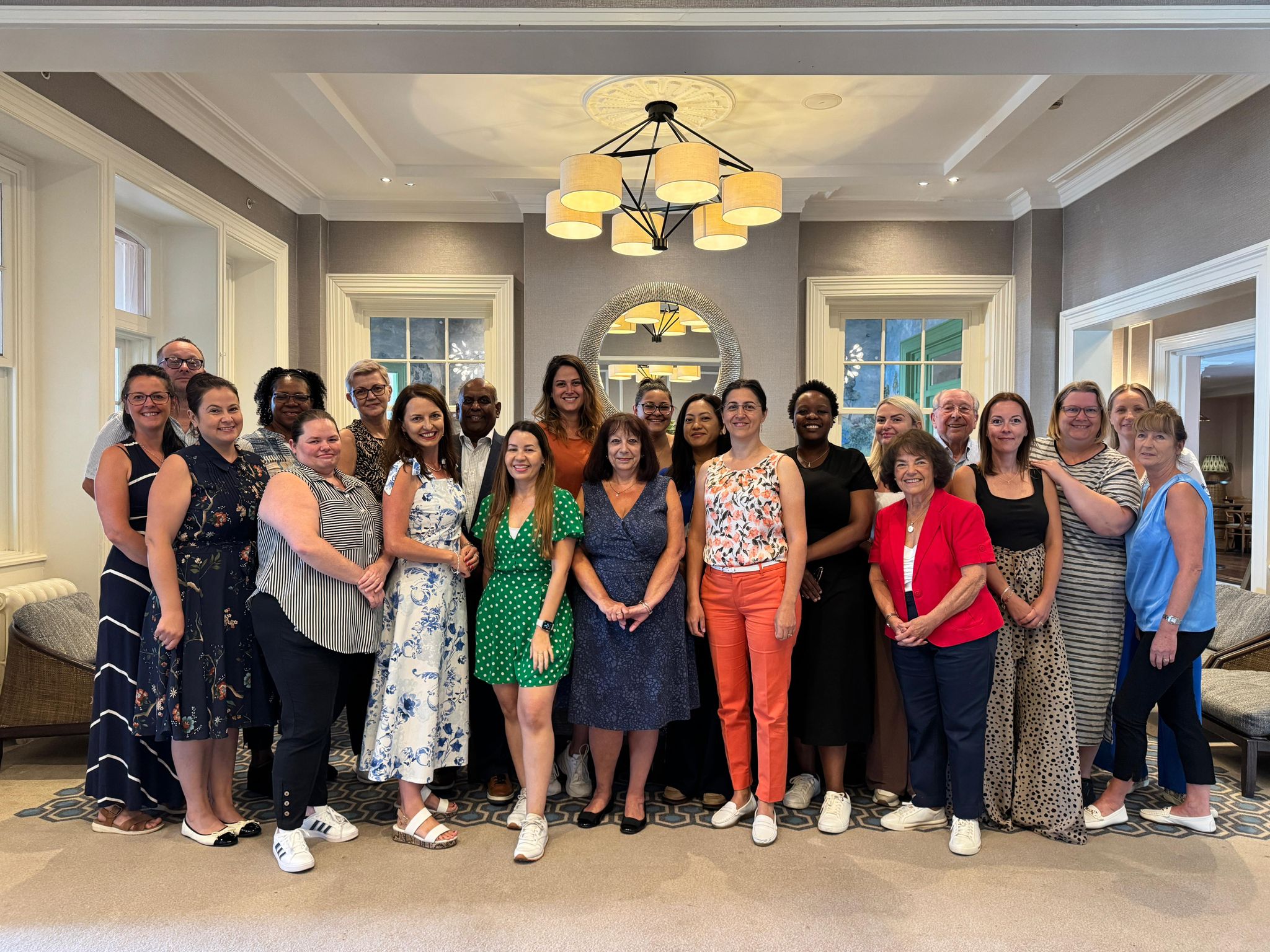 A large group of people stood inside a building smiling 