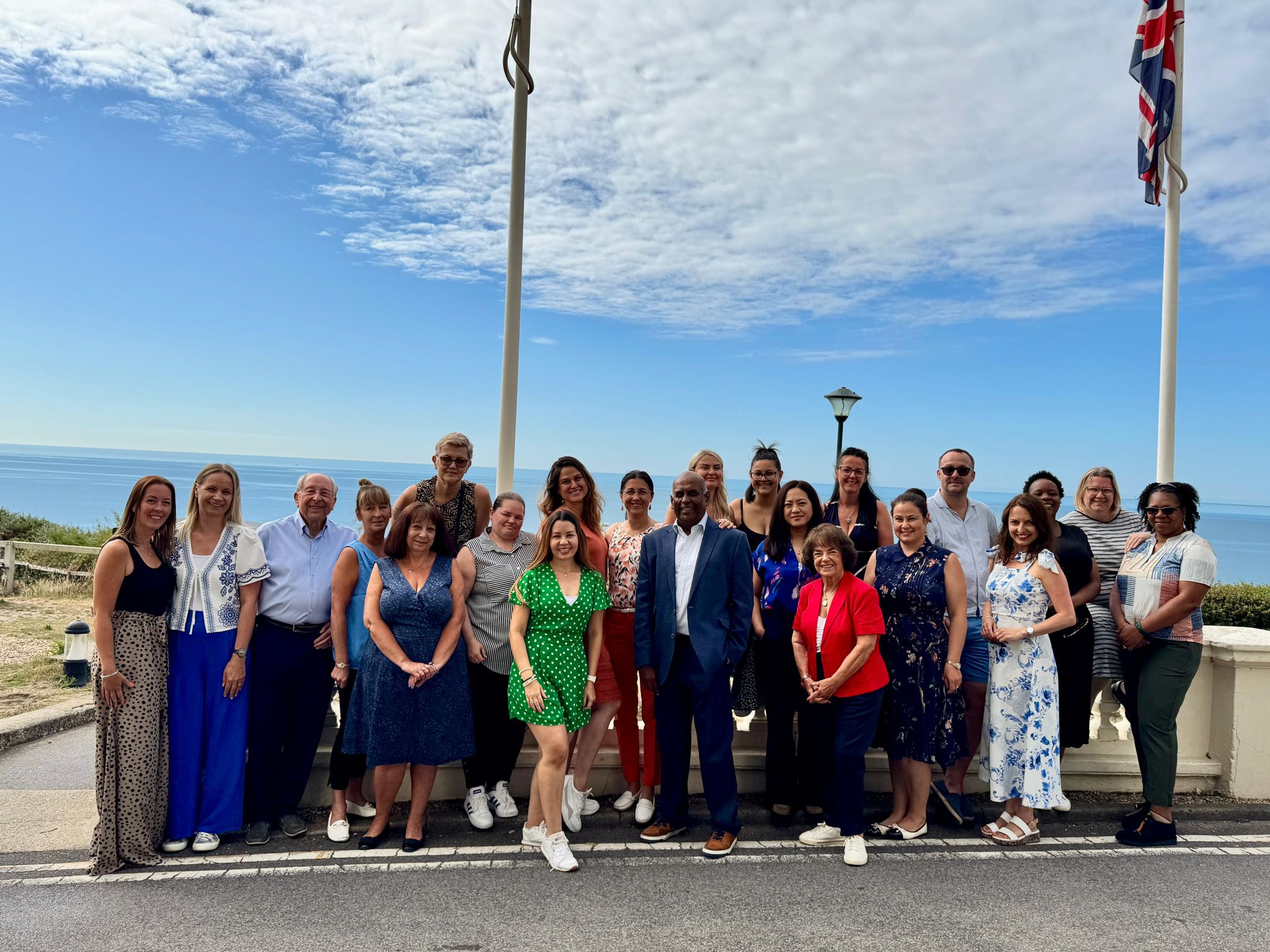A large group of people stood outside in front of a blue sky