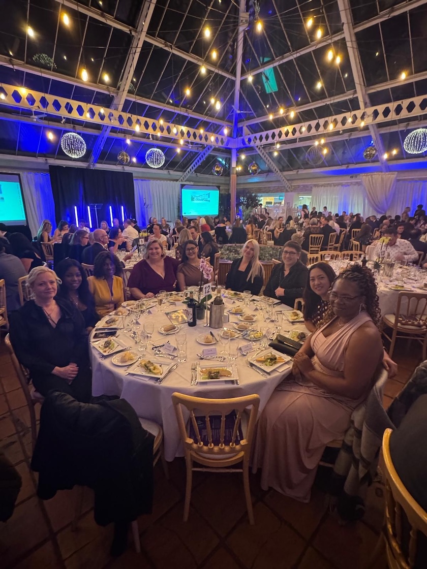 A group of people sat around a table at a formal event 