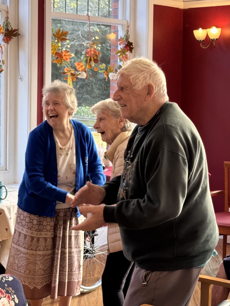 A group of older people smiling and dancing