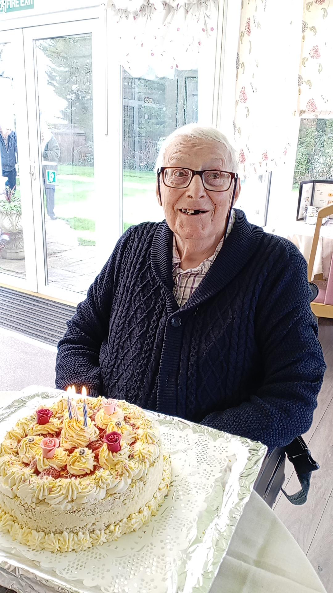 An older gentleman with a birthday cake