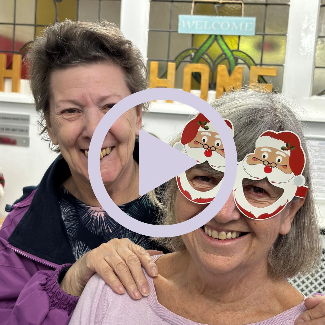 Two smiling ladies, one wearing novelty Christmas glasses