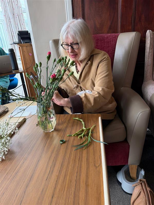 A woman arranging a vase of flowers