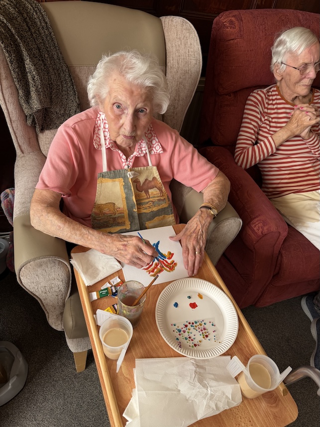An elderly woman painting