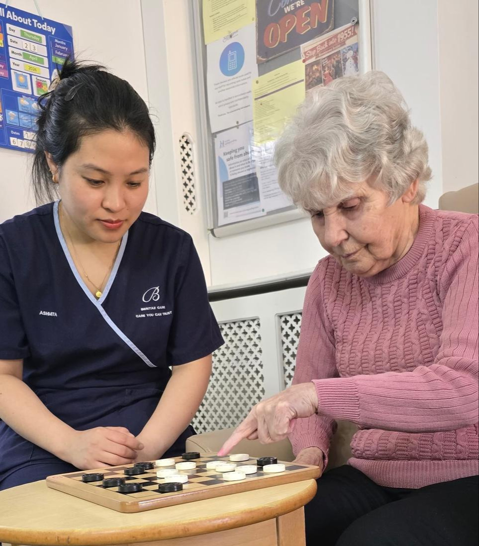 A resident and staff member playing a board game