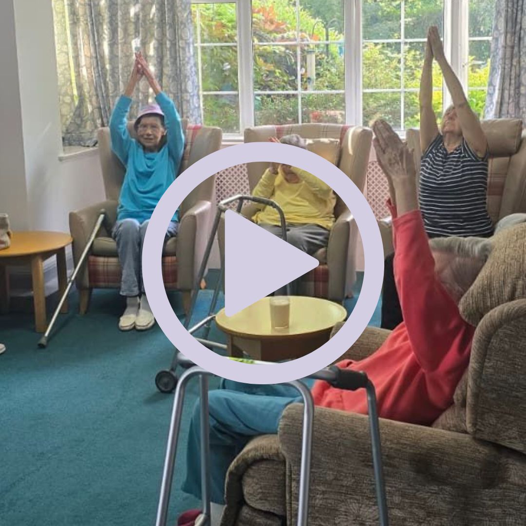 A group of people sat on armchairs doing exercises