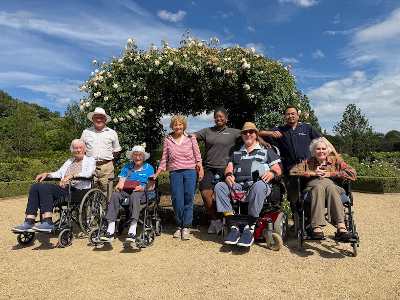 A group of people stood in a garden on a sunny day