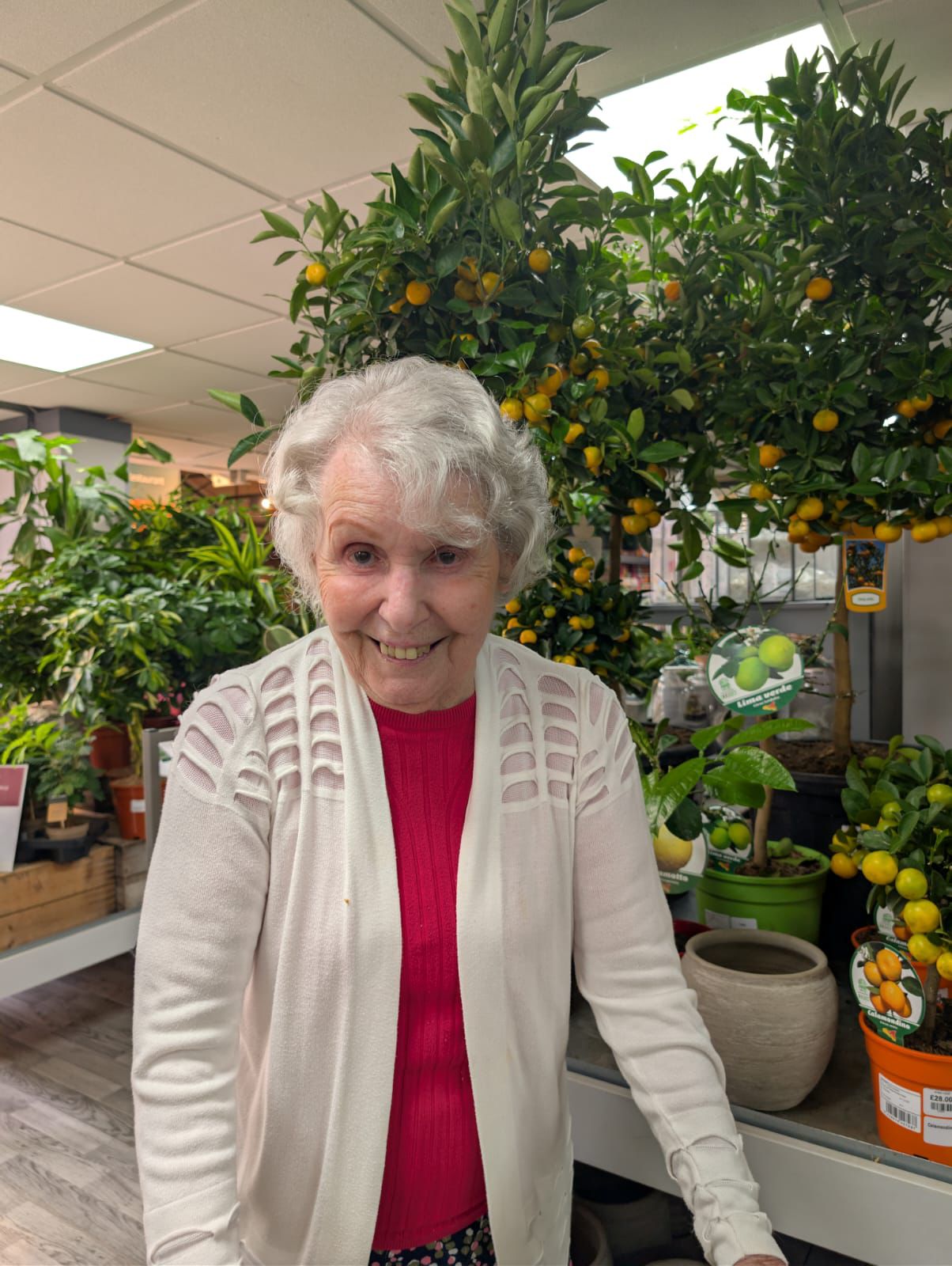 A woman stood in front of plants at a garden centre