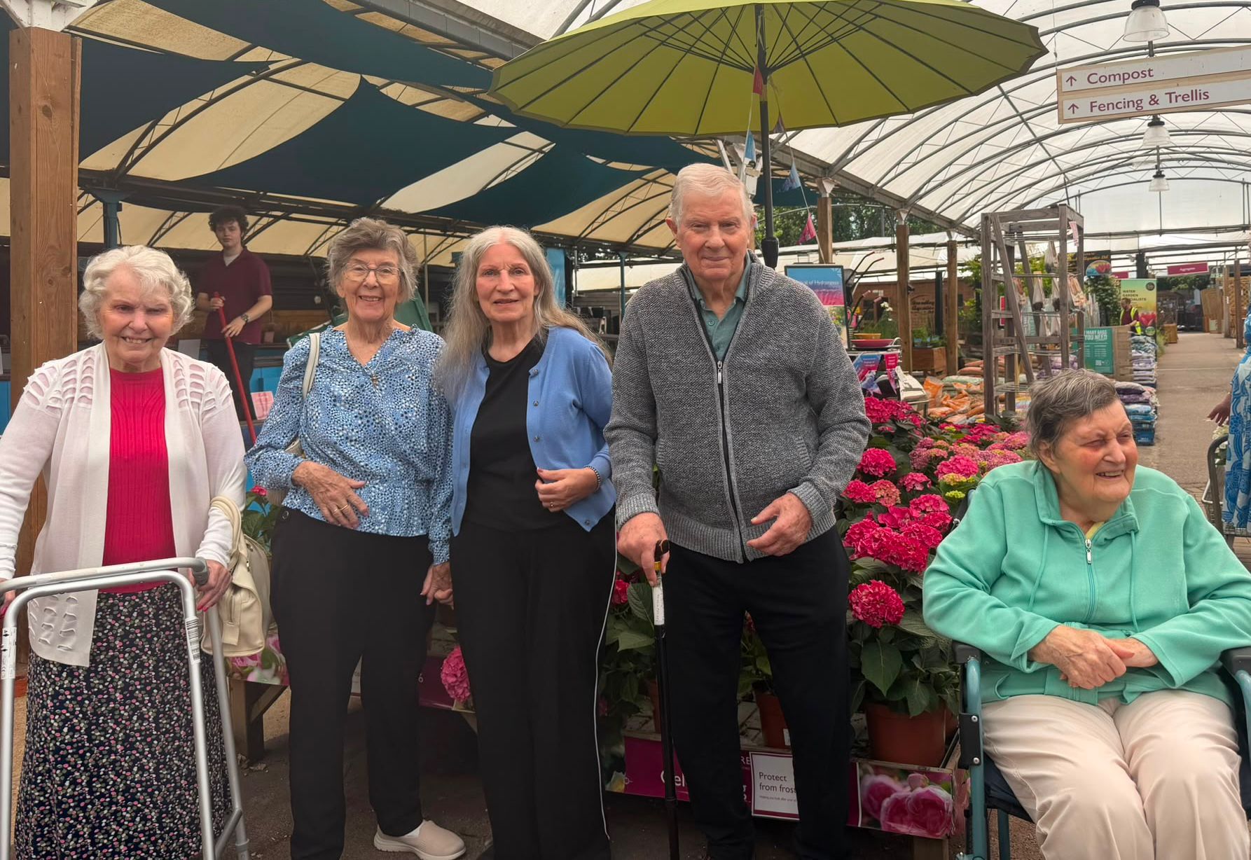 A grouple of people smiling in a garden centre