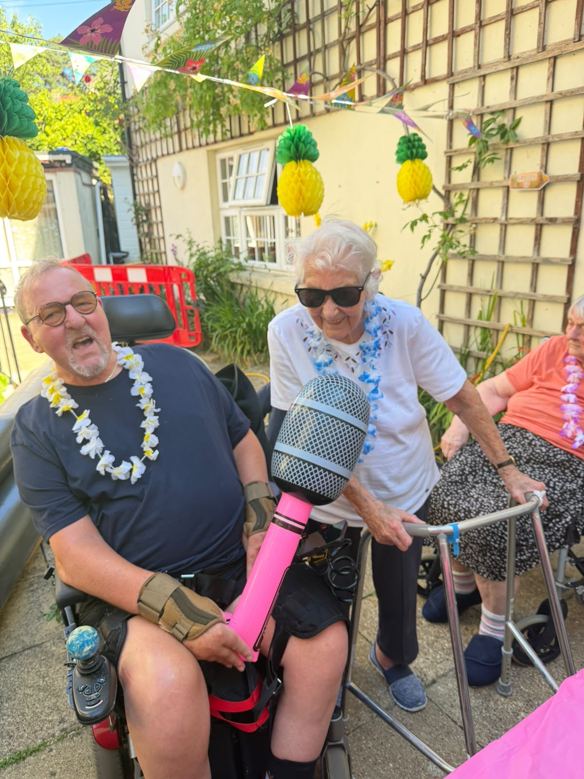 Two people in the garden in the sunshine with sunglasses and inflatables