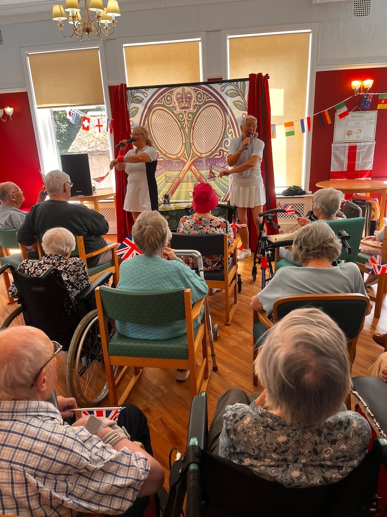 A group of people sat in chairs watching a musical performance.
