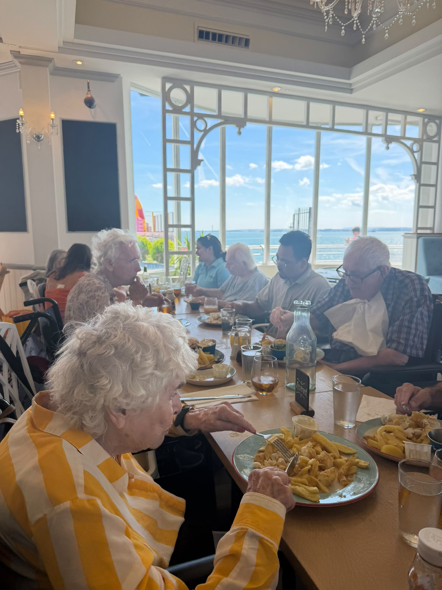 A group of people eating fish and chips in a restaurant