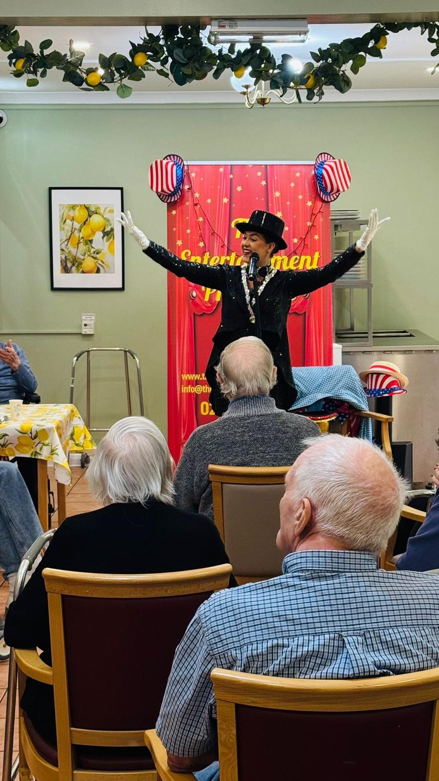 A woman performing in front of a microphone to an audience of people
