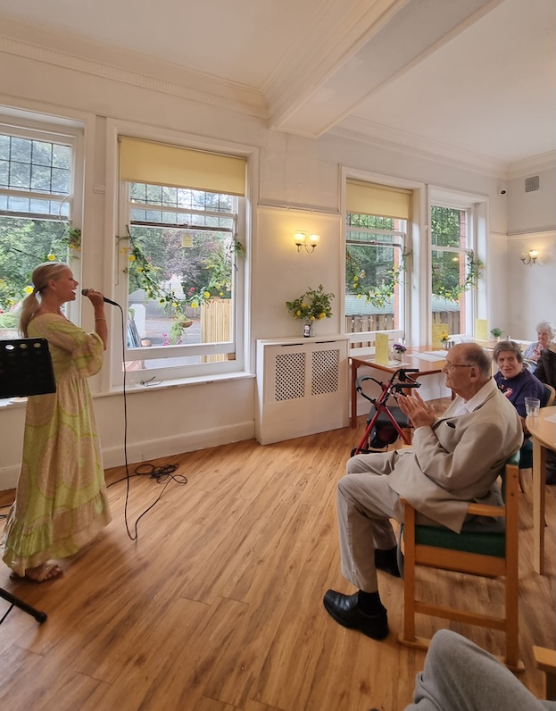 A group of people watching a woman sing