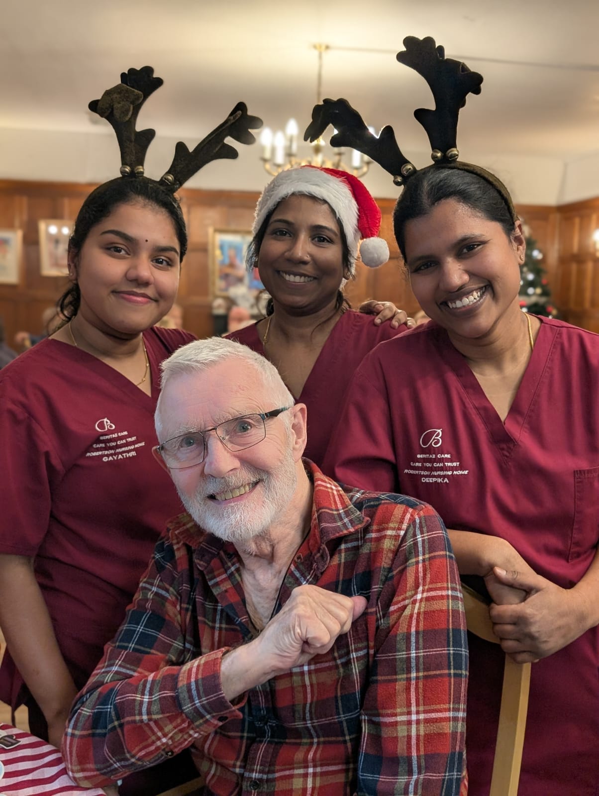 A group of smiling people wearing reindeer horn hats. 