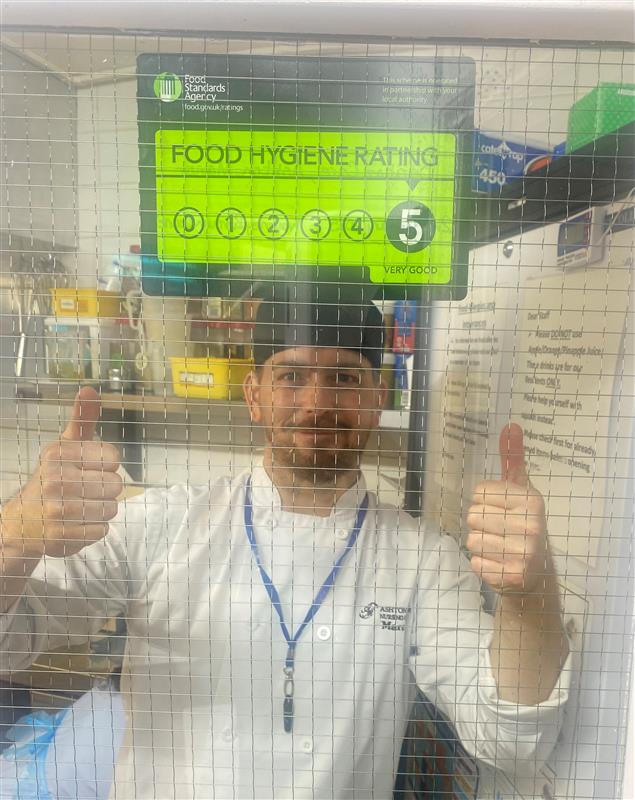 A chef celebrating a 5 out of 5 food safety rating