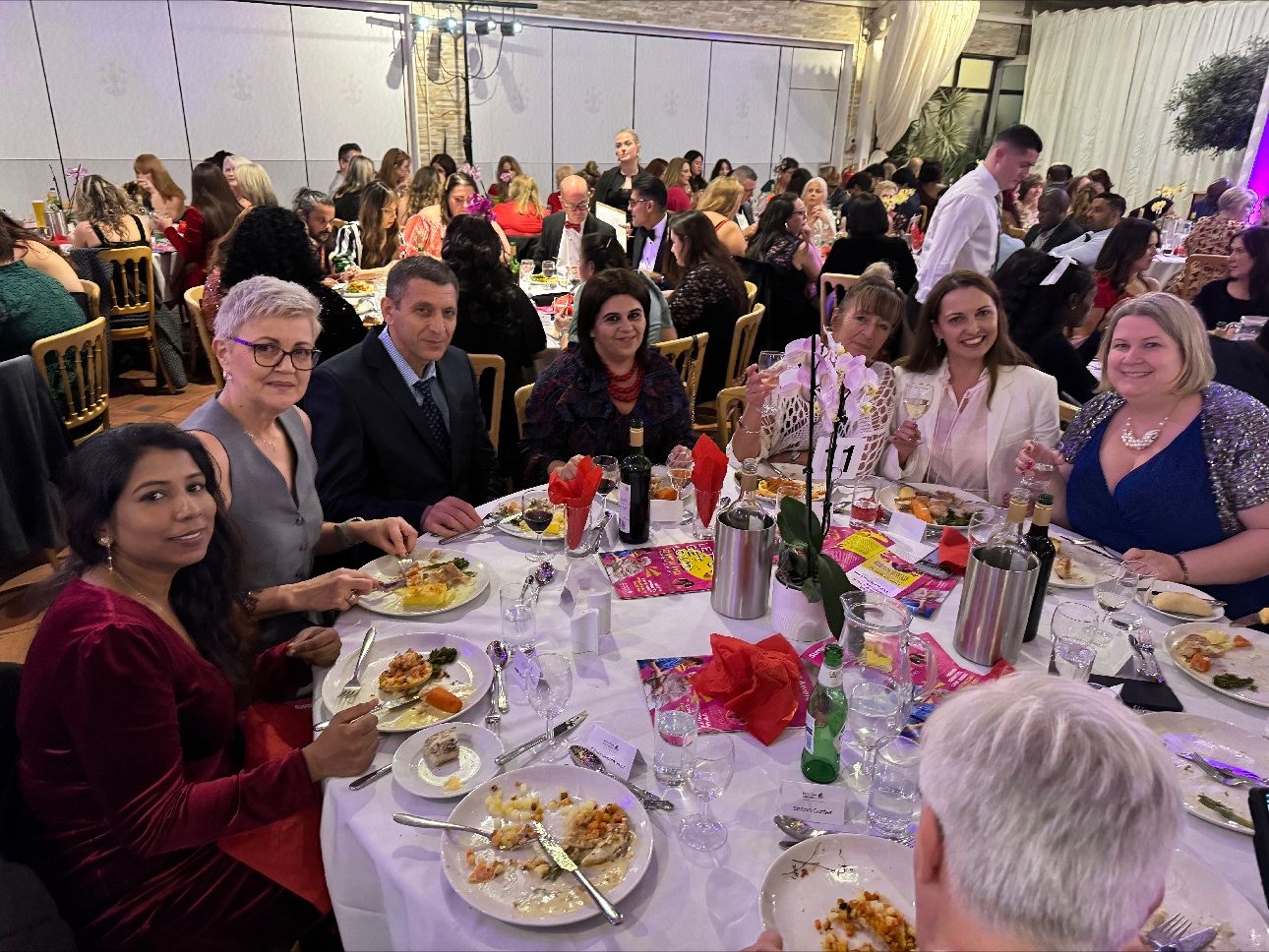 A group of people around a circular table with good food.
