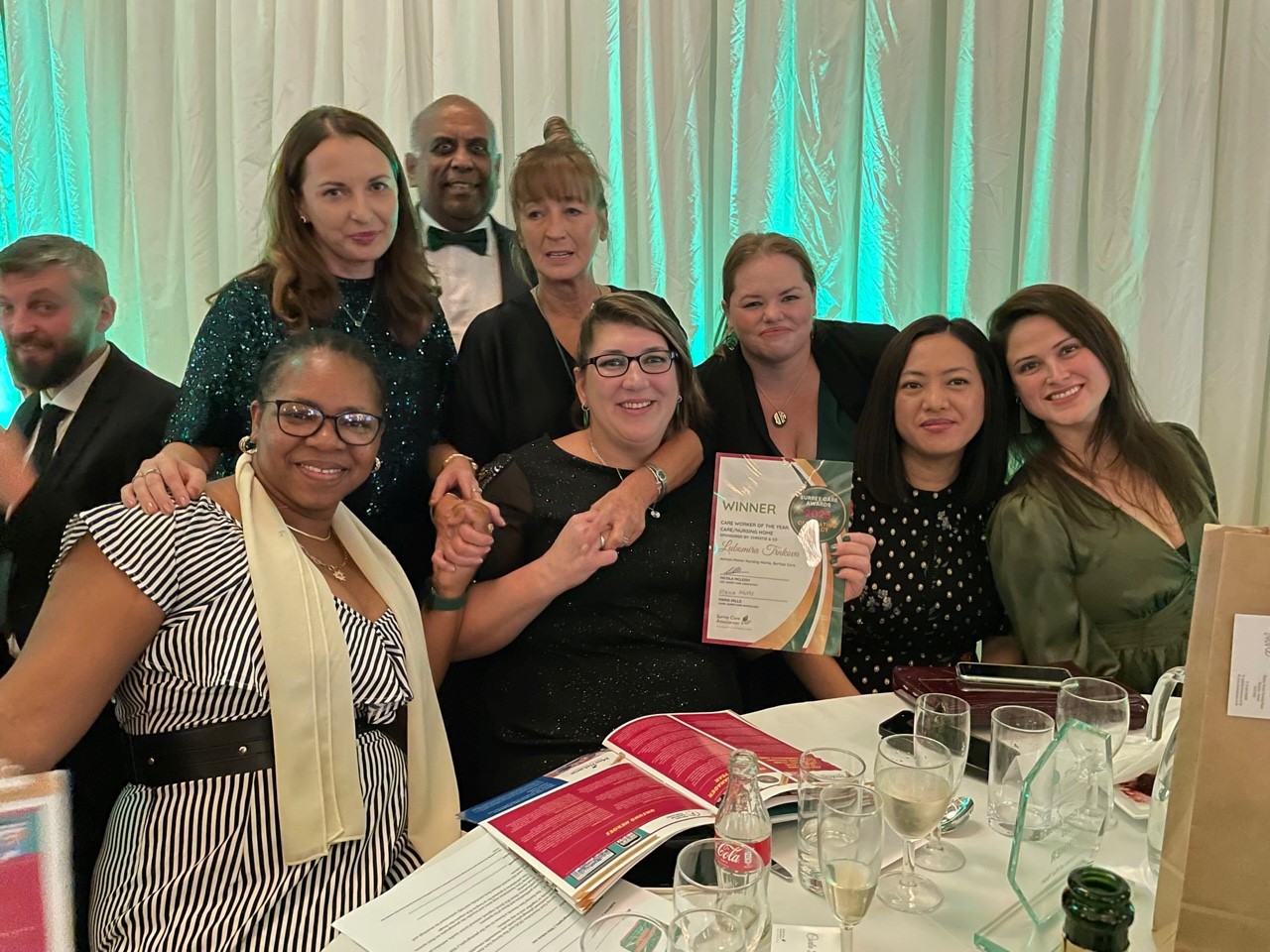 A group of people holding an award with big smiles