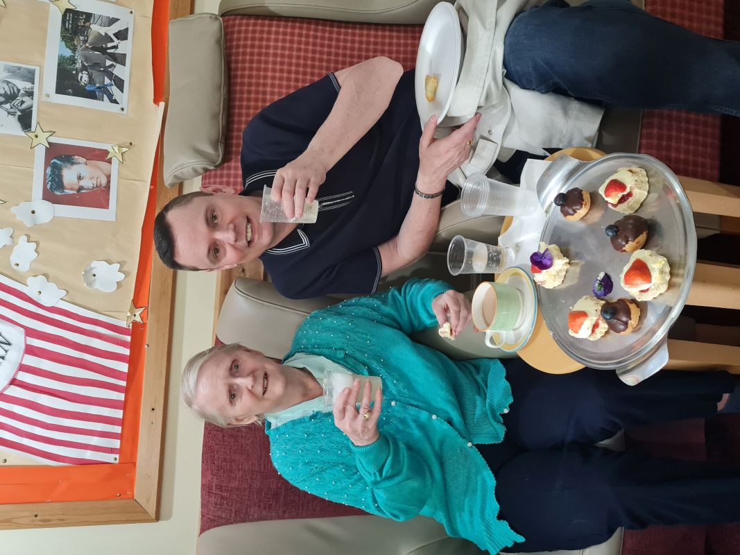 Two people enjoying cake holding up glasses in a toast