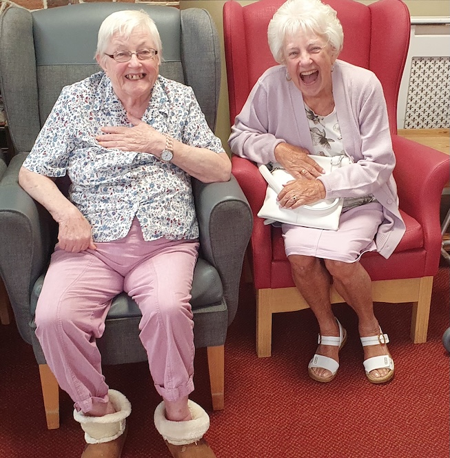 Two older women smiling and laughing