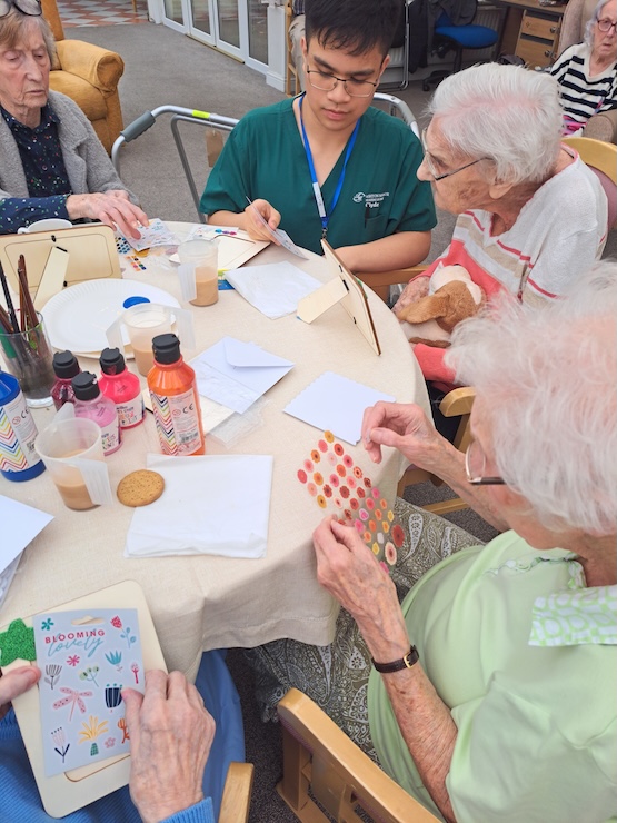 Group of people sat at a table doing arts and crafts