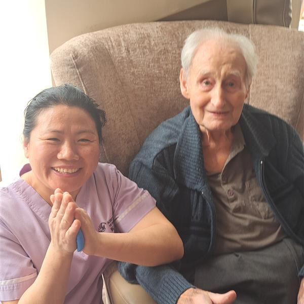 Resident and staff member smiling