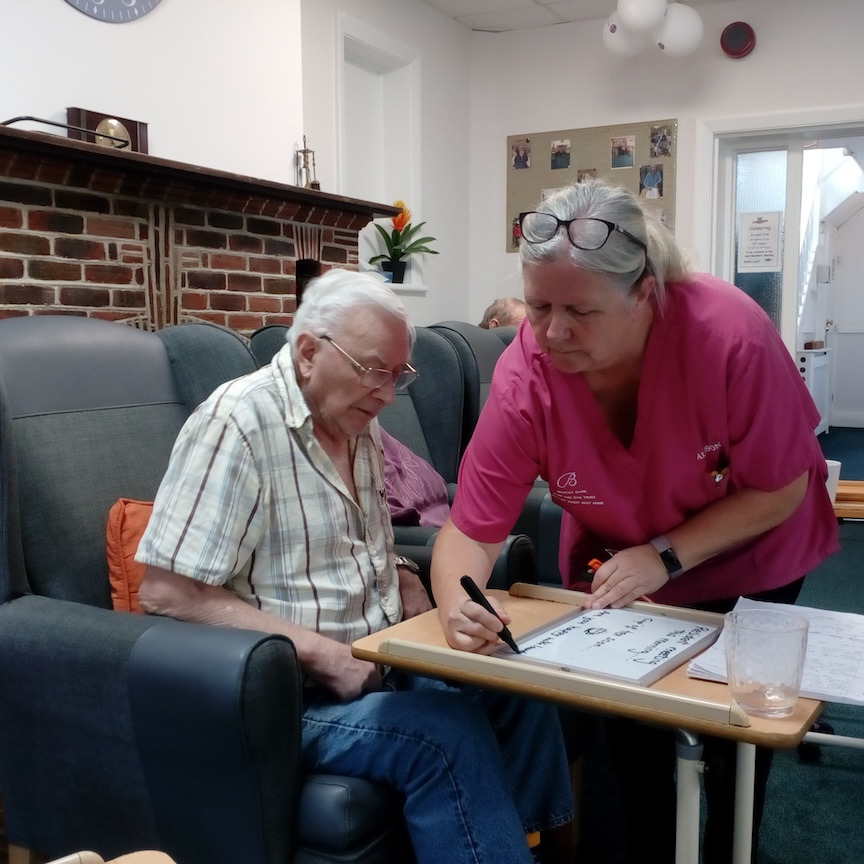 Staff member talking through notes of residents' meeting with a resident