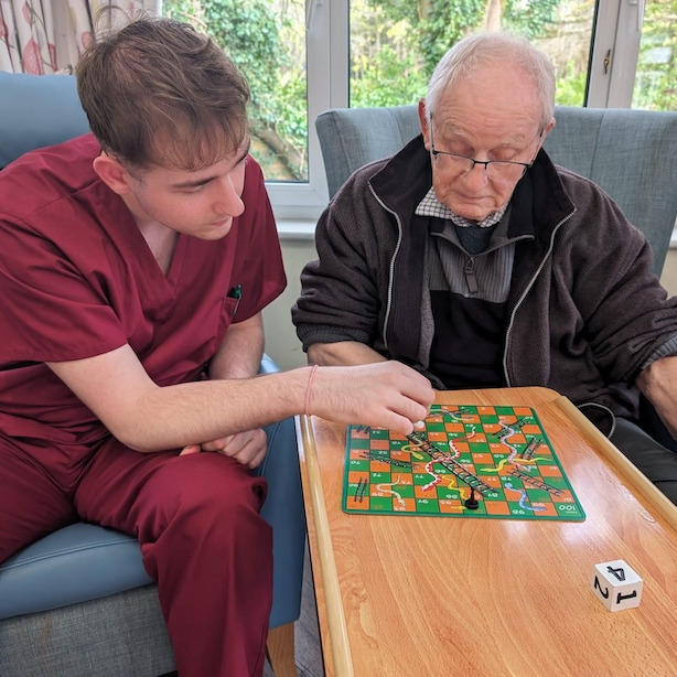 Resident and staff member playing a board game