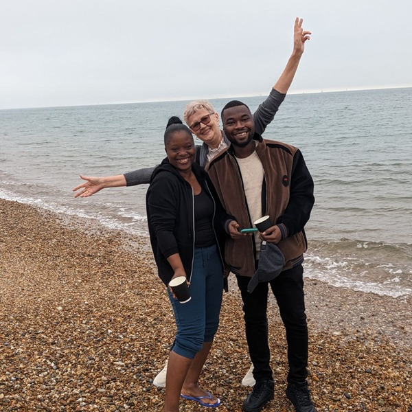 A group of people stood smiling on a beach