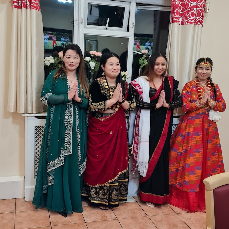 A group of people at a team event dressed in traditional Nepalese outfits