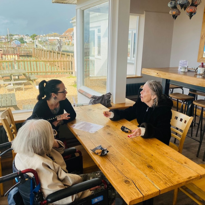 A group of people sat at a table in a cafe talking